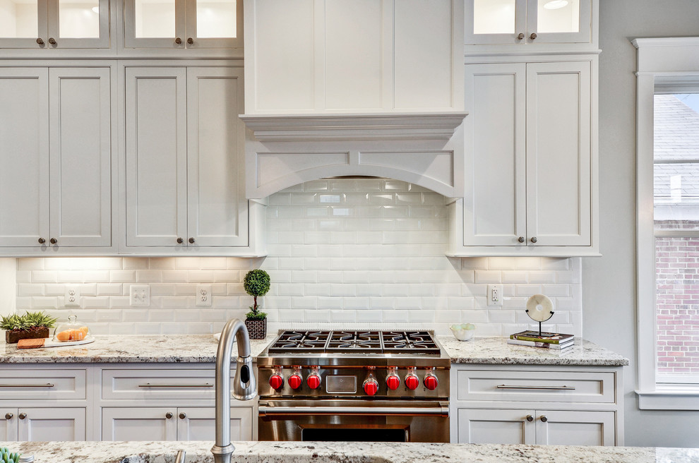 Mid-sized transitional l-shaped medium tone wood floor and brown floor open concept kitchen photo in DC Metro with granite countertops, stainless steel appliances, an island, shaker cabinets, white cabinets, white backsplash and subway tile backsplash