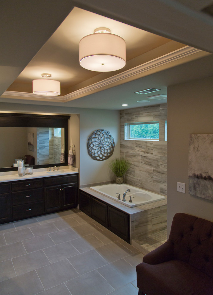 Large transitional master bathroom in Kansas City with louvered cabinets, black cabinets, a corner tub, an alcove shower, gray tile, beige walls, ceramic floors, grey floor and an open shower.