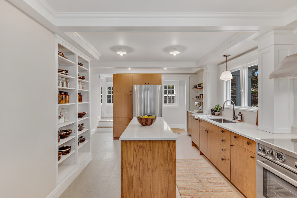 Design ideas for a transitional u-shaped separate kitchen in New York with an undermount sink, flat-panel cabinets, medium wood cabinets, white splashback, stainless steel appliances, with island, beige floor and white benchtop.