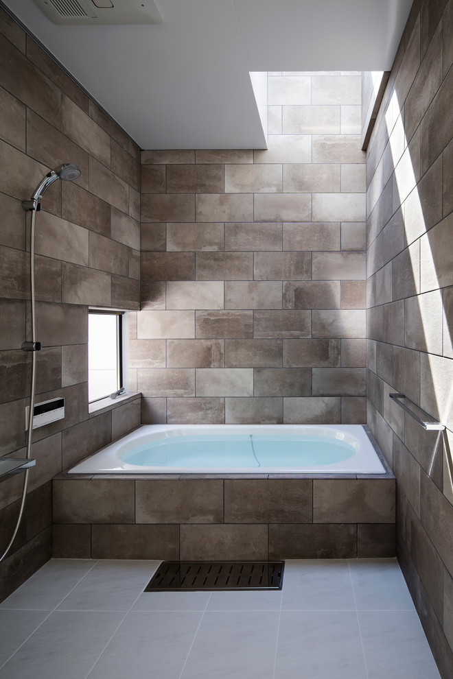 Photo of a mid-sized contemporary master bathroom in Other with a drop-in tub, an open shower, gray tile, ceramic tile, grey walls, ceramic floors, white floor and an open shower.