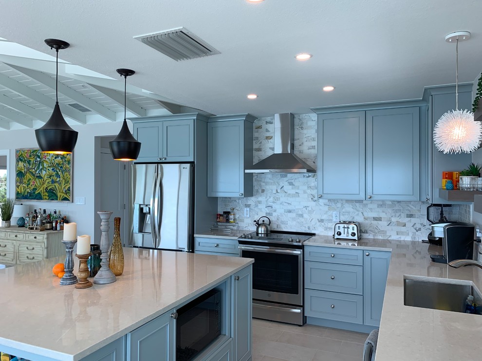 Mid-sized modern l-shaped eat-in kitchen in Miami with with island, an undermount sink, recessed-panel cabinets, blue cabinets, quartz benchtops, grey splashback, marble splashback, stainless steel appliances, porcelain floors, beige floor and white benchtop.