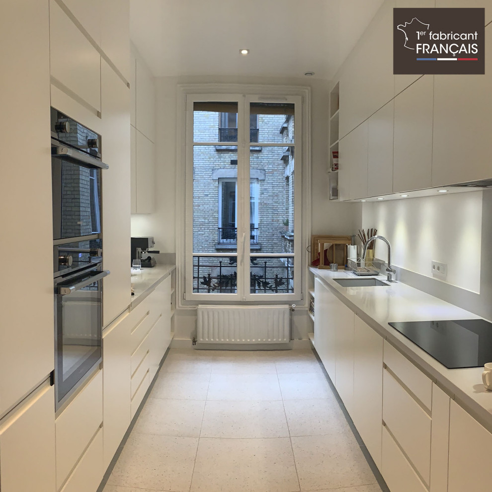 Large minimalist galley white floor enclosed kitchen photo in Paris with an undermount sink, white cabinets, quartzite countertops, metallic backsplash, paneled appliances, no island and white countertops