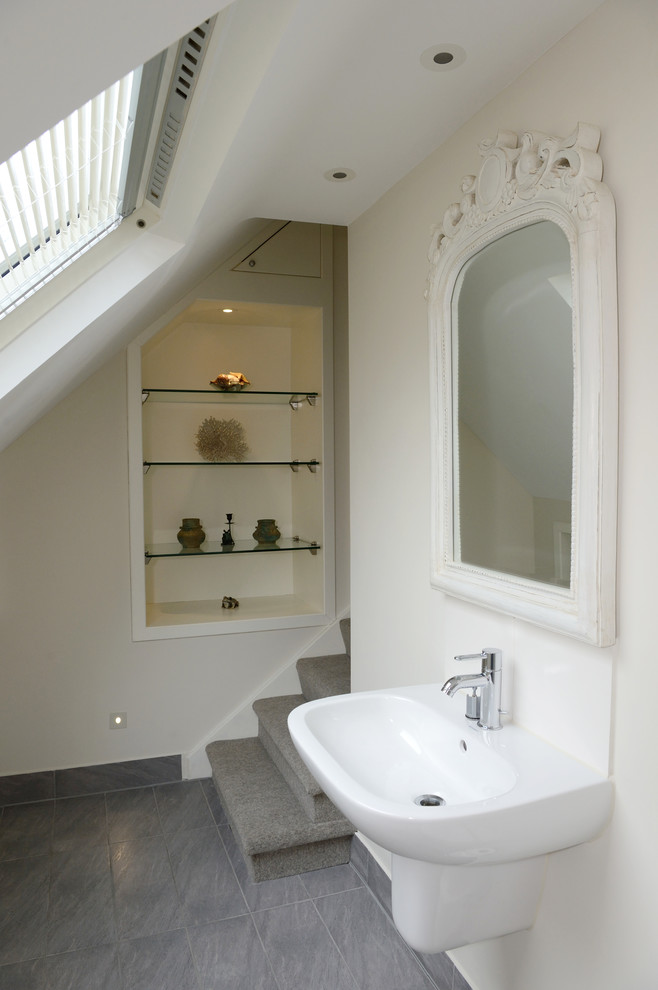 Design ideas for a mid-sized traditional master bathroom in London with white tile, stone slab, beige walls, ceramic floors, a wall-mount sink, grey floor, an open shower, a wall-mount toilet and a hinged shower door.