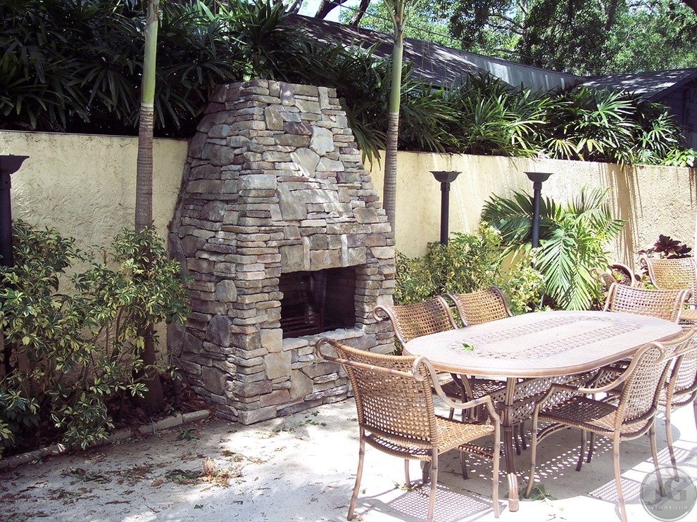 Mid-sized traditional backyard patio in Tampa with a fire feature, concrete slab and no cover.