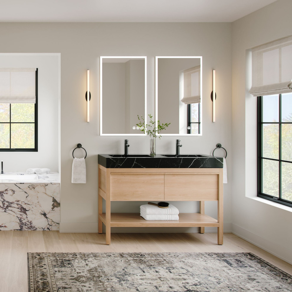 Transitional light wood floor, beige floor and double-sink bathroom photo with flat-panel cabinets, light wood cabinets, an undermount tub, beige walls, an integrated sink, quartz countertops, black countertops and a freestanding vanity