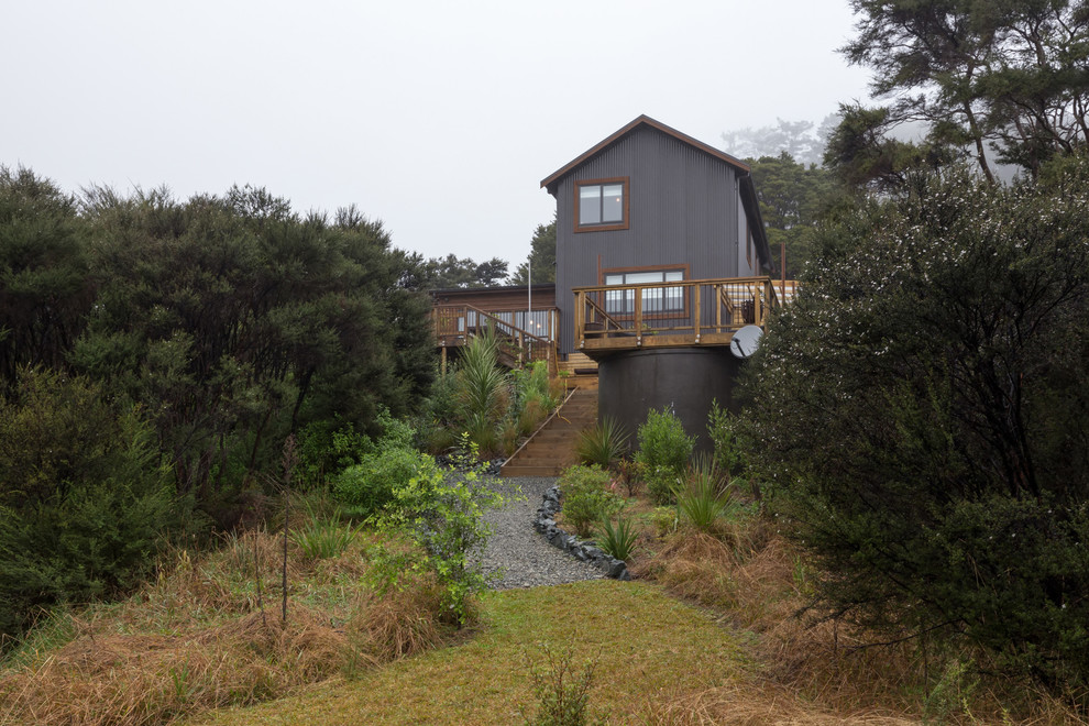Photo of a transitional two-storey grey exterior in Auckland with wood siding and a hip roof.