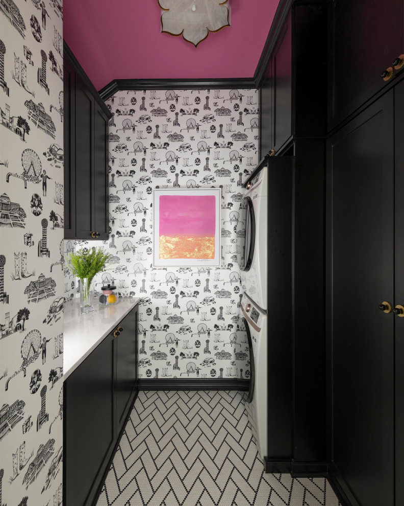 Idee per una sala lavanderia moderna con ante nere, pareti multicolore, lavatrice e asciugatrice a colonna, pavimento multicolore, top bianco e carta da parati