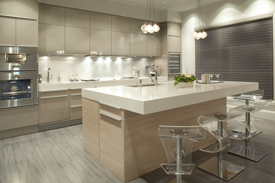 Design ideas for a mid-sized modern single-wall eat-in kitchen in Calgary with an undermount sink, flat-panel cabinets, beige cabinets, quartzite benchtops, white splashback, stone slab splashback, stainless steel appliances, light hardwood floors and with island.