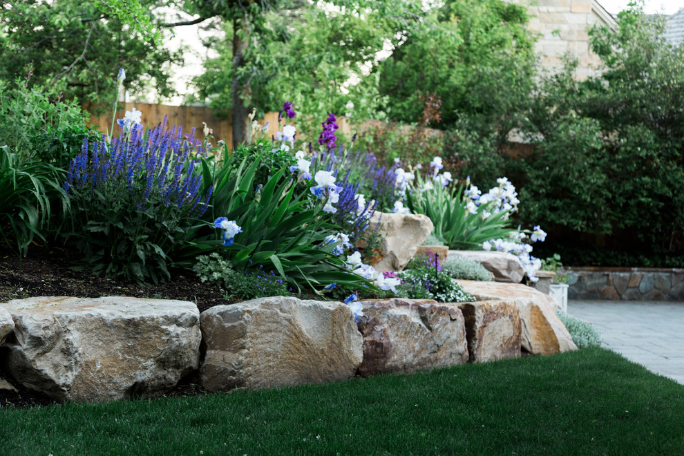This is an example of a traditional garden in Salt Lake City with with flowerbed and river rock.