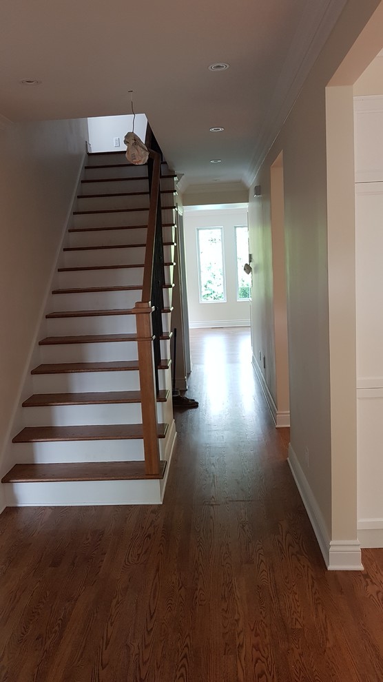 Large transitional wood straight staircase in Montreal with painted wood risers and mixed railing.