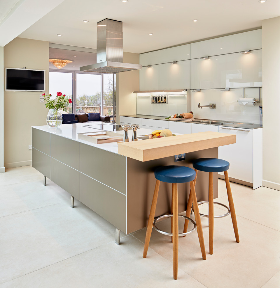 Inspiration for a mid-sized contemporary galley kitchen in Hampshire with flat-panel cabinets, grey cabinets, wood benchtops, white splashback, glass sheet splashback, with island and white floor.