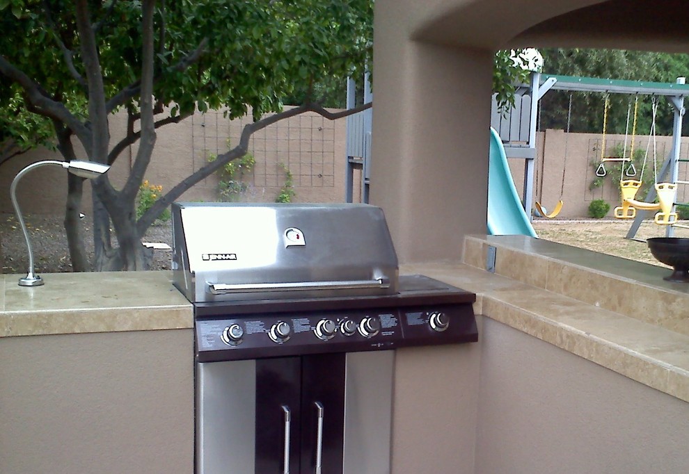 Example of a transitional backyard patio kitchen design in Phoenix with a roof extension