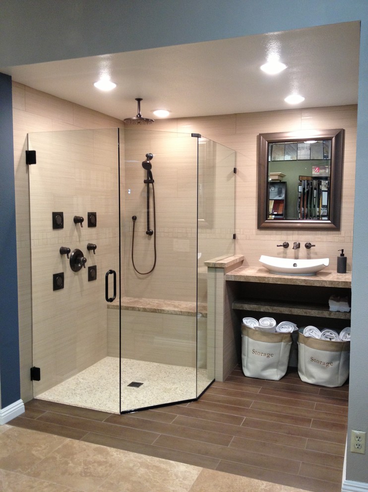 Photo of a mid-sized traditional 3/4 bathroom in Orange County with raised-panel cabinets, medium wood cabinets, a corner shower, a two-piece toilet, gray tile, matchstick tile, blue walls, travertine floors, a vessel sink and quartzite benchtops.
