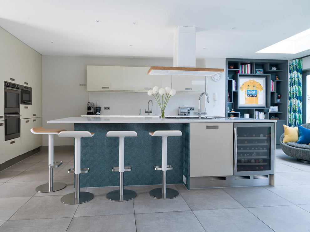 Mid-sized transitional open plan kitchen in Other with flat-panel cabinets, grey splashback, stainless steel appliances, with island, grey floor, grey cabinets and grey benchtop.