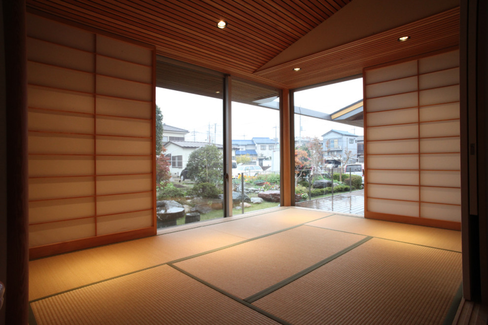 Inspiration for a mid-sized traditional guest bedroom in Other with brown walls, tatami floors, no fireplace, beige floor and wood.