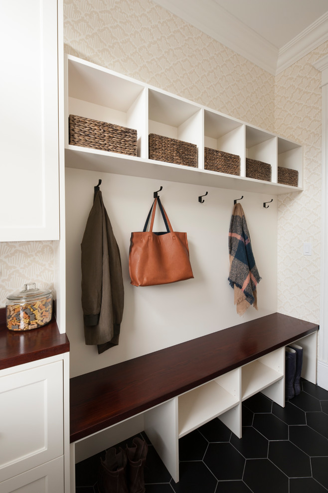 This is an example of a transitional mudroom in Los Angeles with beige walls, ceramic floors and black floor.