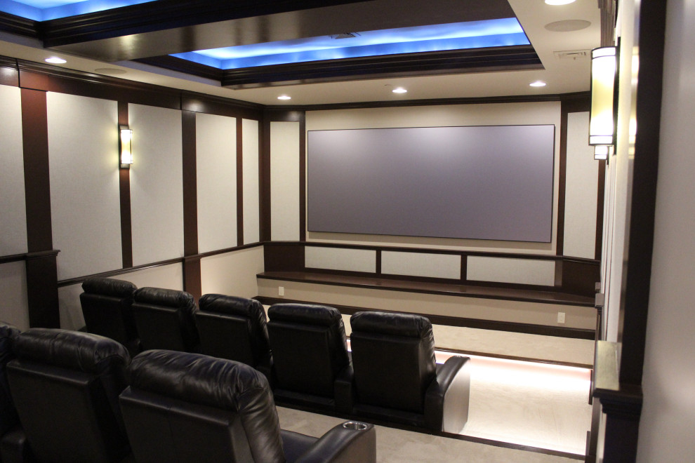 Photo of an expansive traditional enclosed home theatre in Other with beige walls, carpet, a projector screen and beige floor.