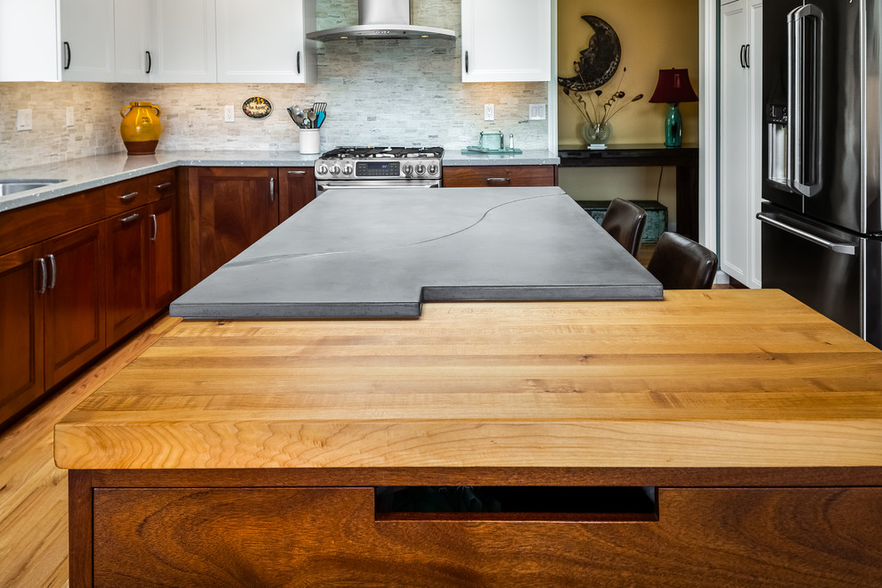 Example of a mid-sized transitional medium tone wood floor kitchen design with a single-bowl sink, recessed-panel cabinets, concrete countertops, stone tile backsplash, stainless steel appliances, an island and gray countertops