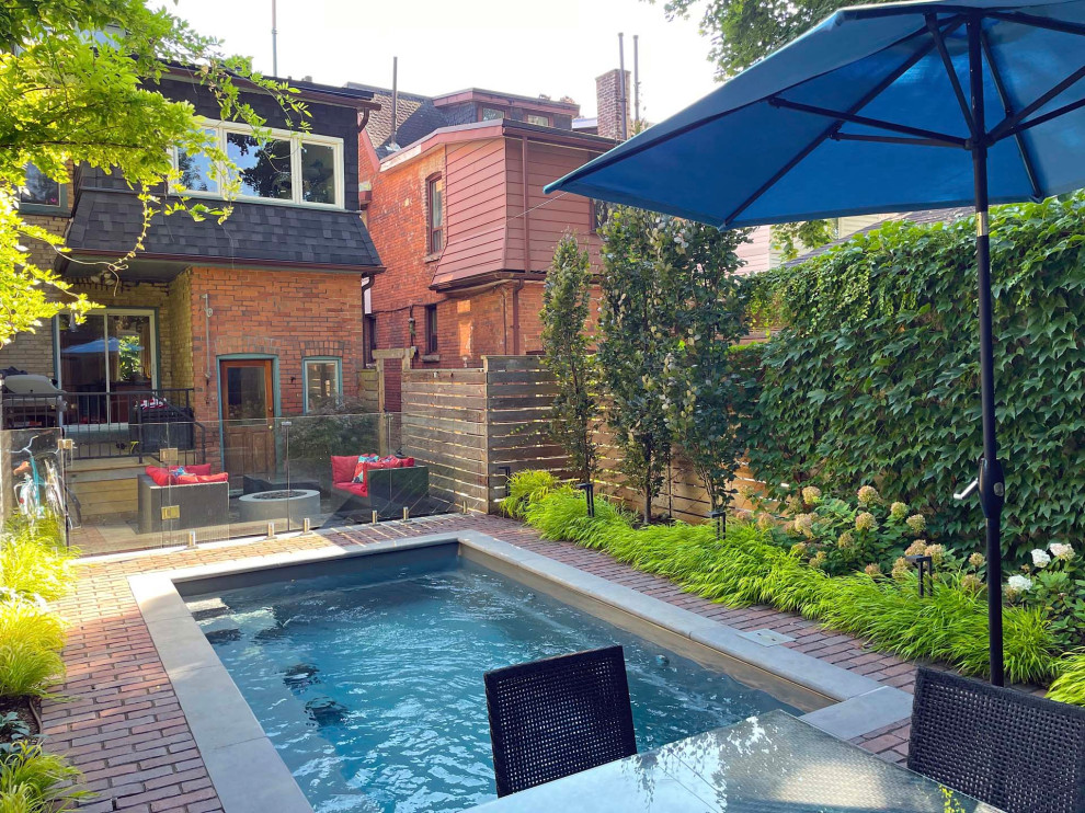 Inspiration for a mid-sized eclectic full sun backyard concrete paver and wood fence landscaping in Toronto.