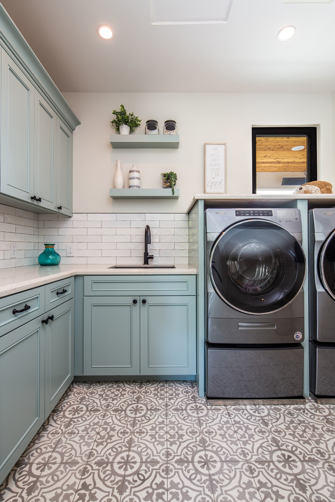 Inspiration for a mid-sized contemporary l-shaped dedicated laundry room in San Diego with an undermount sink, recessed-panel cabinets, blue cabinets, beige walls, a side-by-side washer and dryer, beige benchtop, quartz benchtops, ceramic floors and multi-coloured floor.