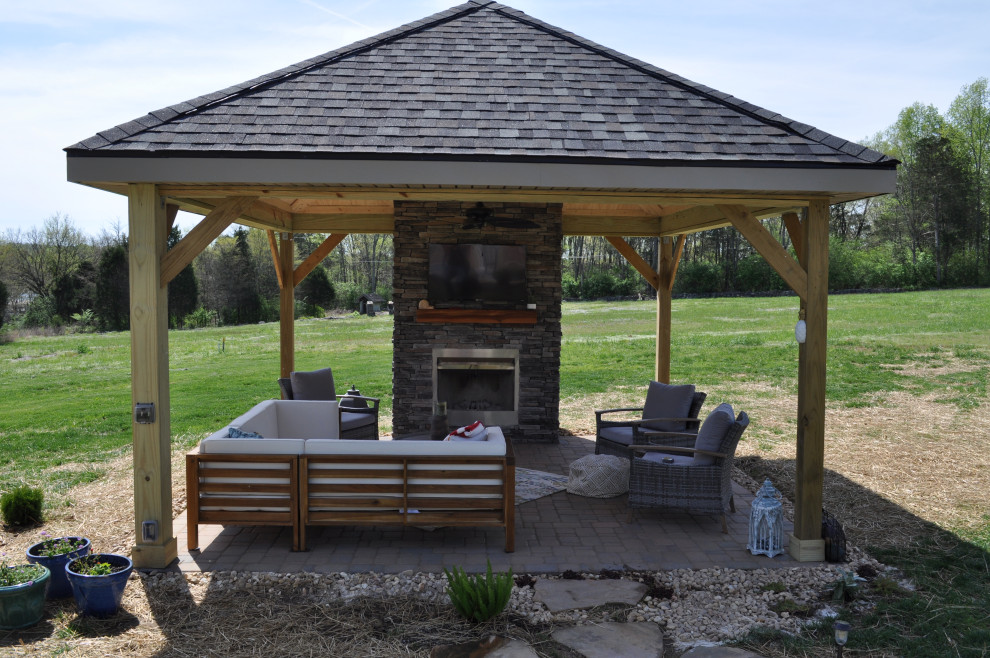 Inspiration for a rustic backyard concrete paver patio remodel in Nashville with a fireplace