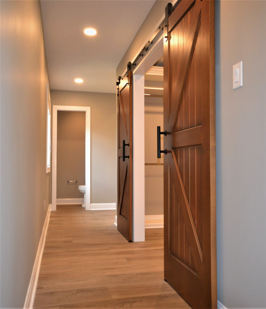 This is an example of a large traditional gender neutral walk-in wardrobe in Philadelphia with vinyl flooring and brown floors.