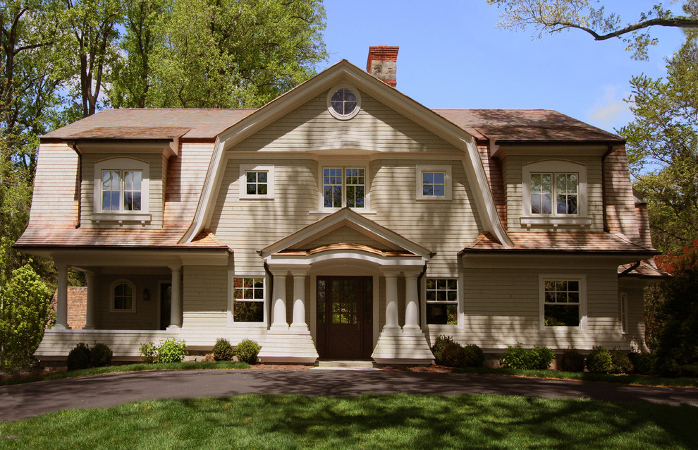 Photo of a mid-sized traditional two-storey exterior in New York with wood siding and a gambrel roof.