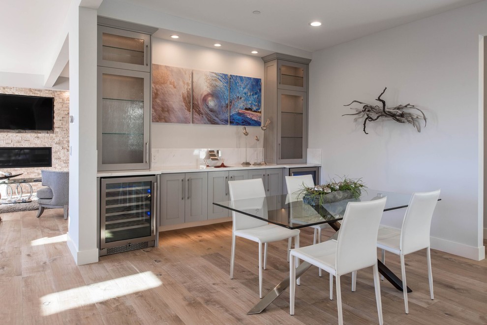 Example of a mid-sized transitional light wood floor great room design in Orange County with gray walls, a ribbon fireplace and a stone fireplace