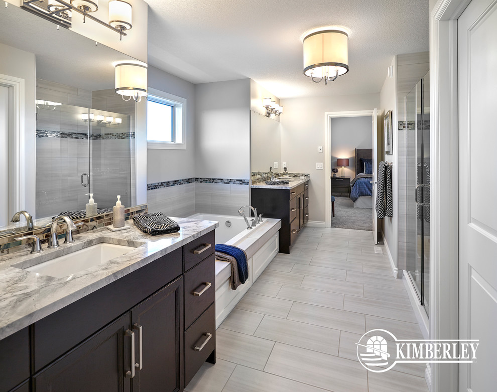 Large transitional master bathroom in Edmonton with recessed-panel cabinets, dark wood cabinets, a drop-in tub, an alcove shower, gray tile, ceramic tile, an undermount sink and engineered quartz benchtops.