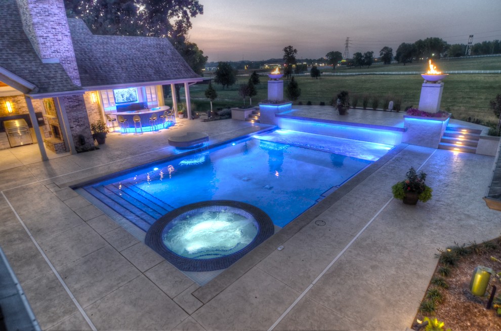 Example of a large transitional backyard concrete paver and rectangular natural hot tub design in Cedar Rapids