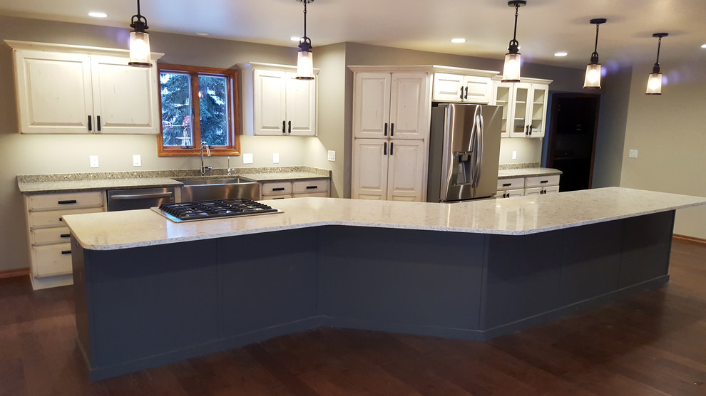 Inspiration for a large transitional galley medium tone wood floor open concept kitchen remodel with a farmhouse sink, raised-panel cabinets, white cabinets, quartz countertops, stainless steel appliances and an island