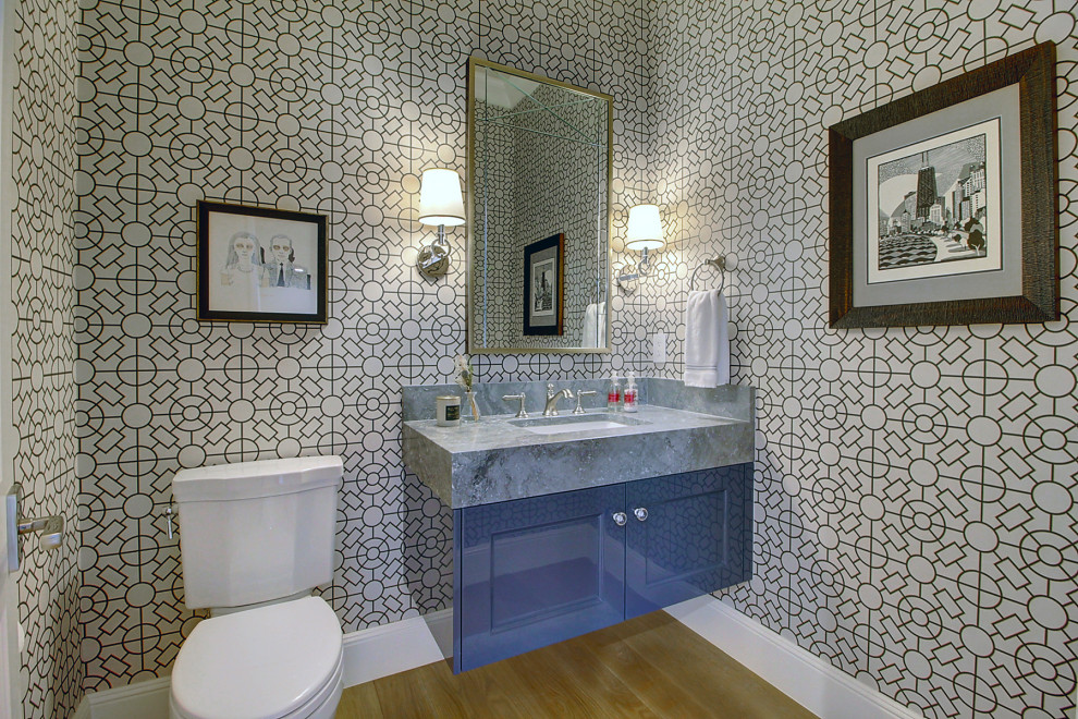 Пример оригинального дизайна: огромный туалет в стиле неоклассика (современная классика) с фасадами с выступающей филенкой, синими фасадами, унитазом-моноблоком, серыми стенами, светлым паркетным полом, врезной раковиной, мраморной столешницей, коричневым полом, серой столешницей, подвесной тумбой и обоями на стенах