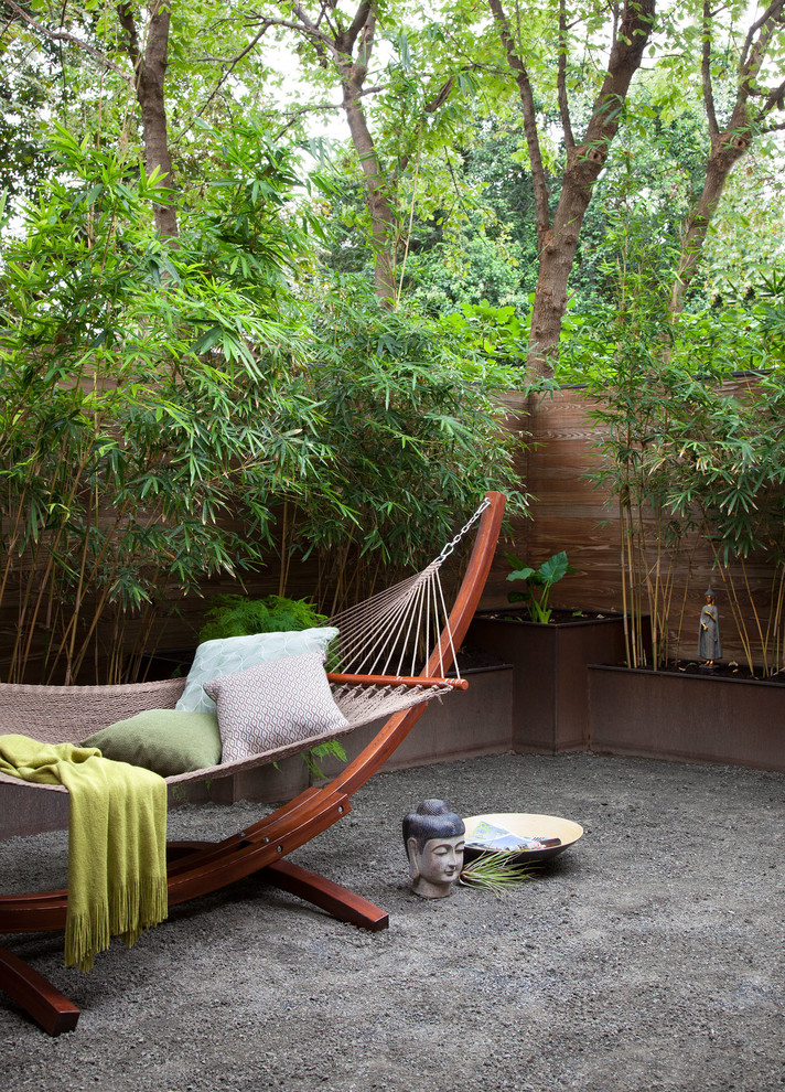 Inspiration for a mid-sized asian garden in Austin with gravel and a retaining wall.