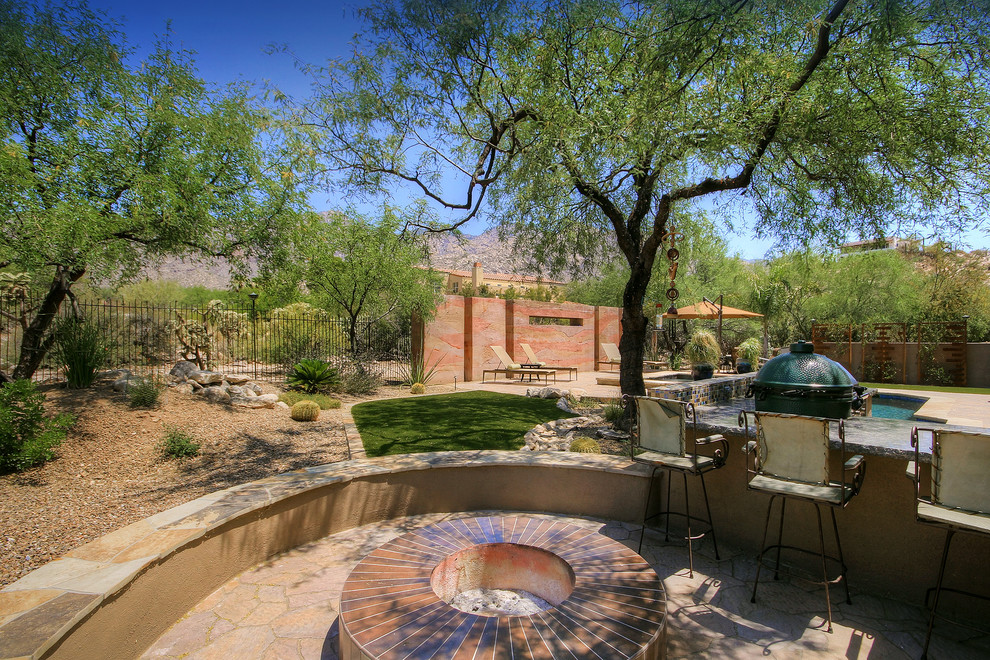 Photo of a large country backyard partial sun xeriscape in Phoenix with concrete pavers, with privacy feature and a metal fence.