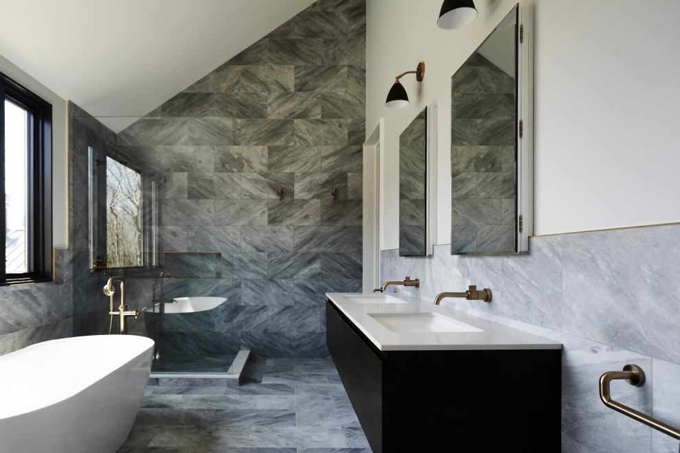 Inspiration for a large contemporary master bathroom in New York with flat-panel cabinets, dark wood cabinets, a freestanding tub, an alcove shower, gray tile, marble, white walls, marble floors, an undermount sink, marble benchtops, grey floor, an open shower, white benchtops, a double vanity, a floating vanity and vaulted.