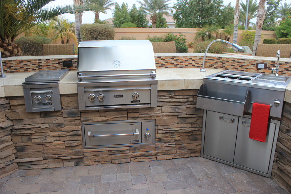Inspiration for a large backyard patio in Phoenix with an outdoor kitchen, brick pavers and no cover.