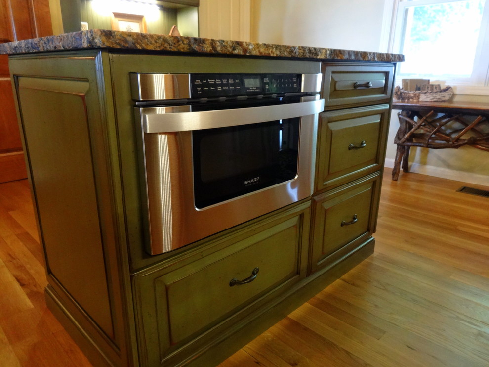 Inspiration for a mid-sized rustic l-shaped medium tone wood floor eat-in kitchen remodel in Charlotte with a farmhouse sink, raised-panel cabinets, dark wood cabinets, granite countertops, multicolored backsplash, stone tile backsplash, stainless steel appliances and an island