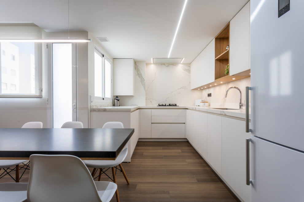 Design ideas for a large scandinavian l-shaped eat-in kitchen in Valencia with an undermount sink, stainless steel appliances, porcelain floors and brown floor.