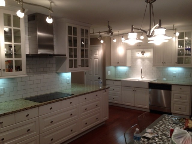 Example of a transitional kitchen design in Chicago with glass-front cabinets, white cabinets, granite countertops, white backsplash and subway tile backsplash