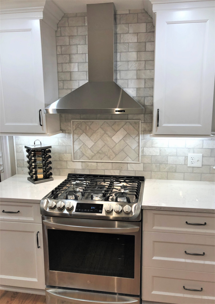 Foto di una grande cucina tradizionale con lavello sottopiano, ante con bugna sagomata, ante bianche, top in quarzite, paraspruzzi grigio, paraspruzzi con piastrelle diamantate, elettrodomestici in acciaio inossidabile, parquet chiaro, pavimento marrone e top bianco