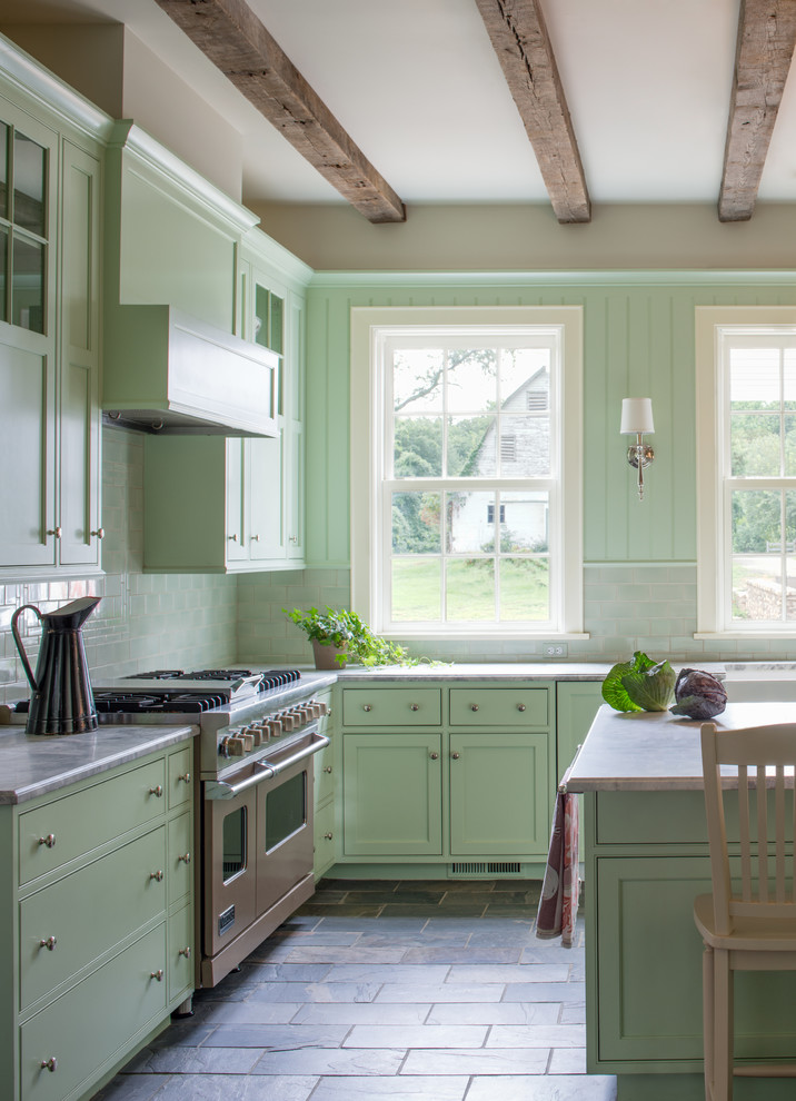 This is an example of a country u-shaped eat-in kitchen in DC Metro with flat-panel cabinets, green cabinets, marble benchtops, green splashback, subway tile splashback, stainless steel appliances and slate floors.