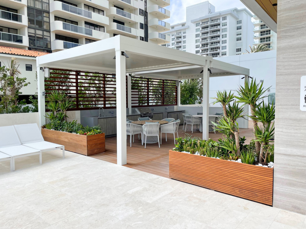 Réalisation d'une grande terrasse sur le toit marine avec une cuisine d'été, une cour et une pergola.