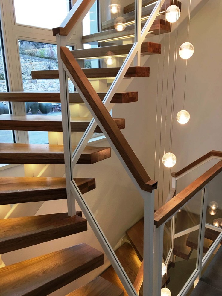 Стильный дизайн: большая изогнутая лестница в современном стиле с деревянными ступенями - последний тренд