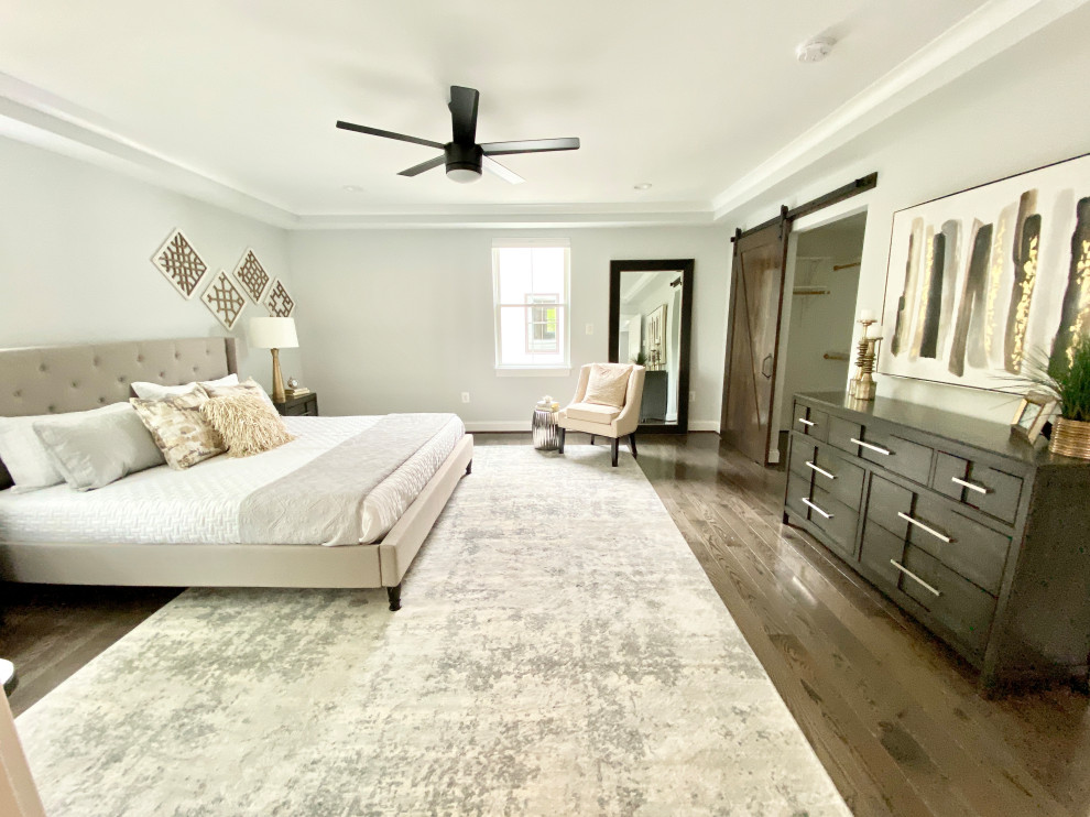 Inspiration for a large transitional master bedroom in DC Metro with grey walls, medium hardwood floors and brown floor.
