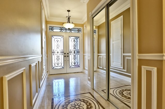Example of a large classic marble floor foyer design in Toronto with beige walls and a white front door