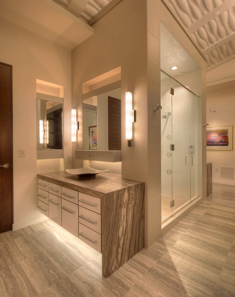 This is an example of a contemporary bathroom in Milwaukee with a vessel sink, flat-panel cabinets, white cabinets, marble benchtops, an alcove shower, gray tile and stone tile.
