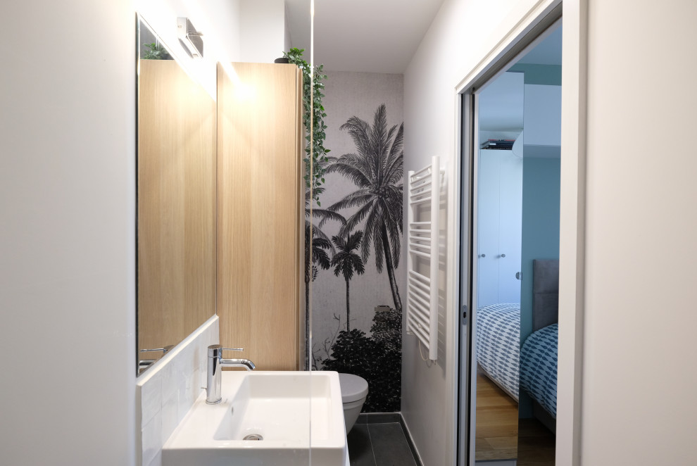 Стильный дизайн: маленькая главная ванная комната в скандинавском стиле с плоскими фасадами, светлыми деревянными фасадами, инсталляцией, белой плиткой, керамической плиткой, белыми стенами, подвесной раковиной, столешницей из дерева, серым полом, тумбой под одну раковину, подвесной тумбой и обоями на стенах для на участке и в саду - последний тренд