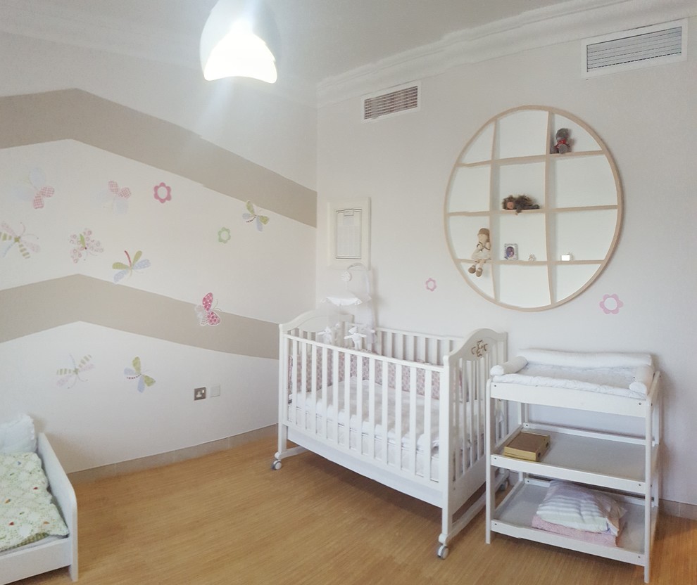 This is an example of a mid-sized transitional nursery for girls in Other with beige walls and linoleum floors.