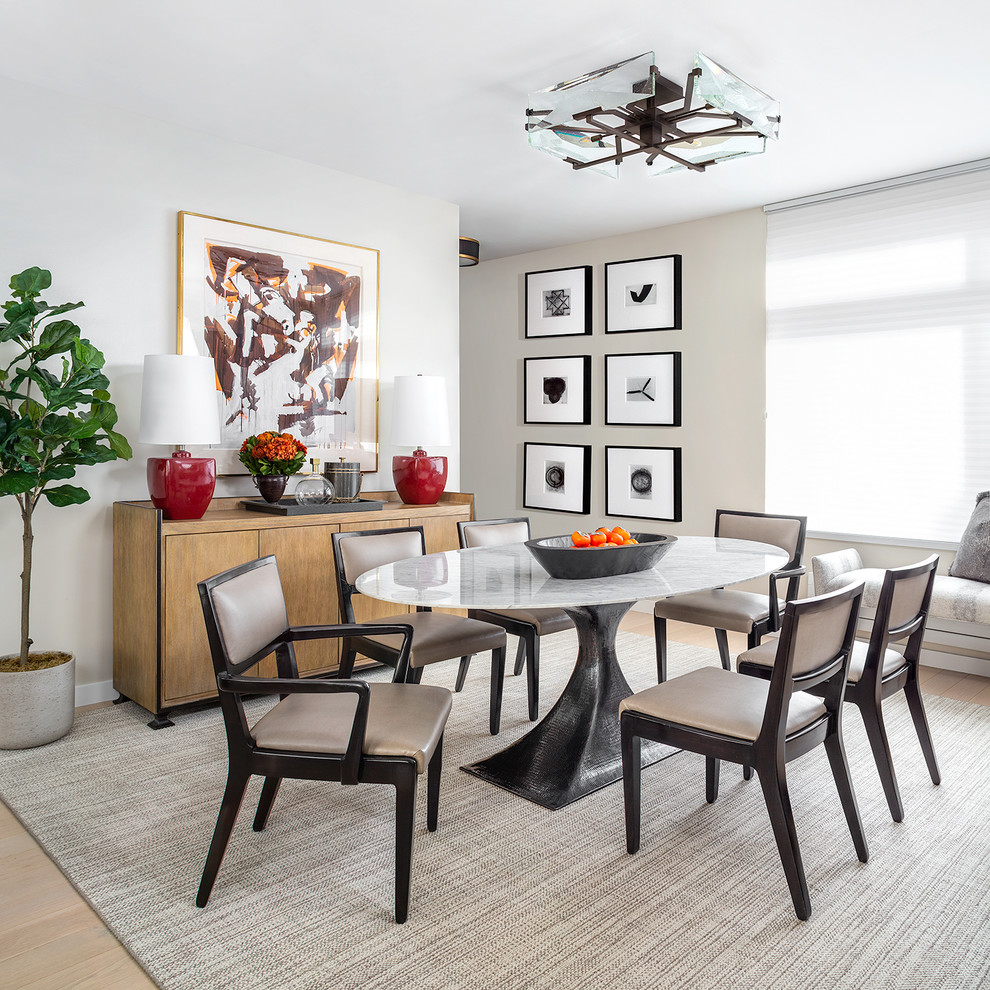 This is an example of a contemporary dining room in New York with beige walls, light hardwood floors and beige floor.