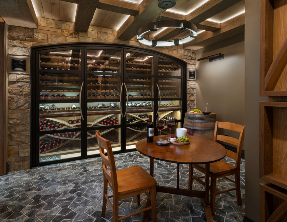 Large arts and crafts wine cellar in Denver with terra-cotta floors, display racks and black floor.